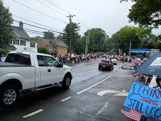 Demonstration on Prime Avenue in Huntington, showing No Kings protestors filling the sidewalks on both sides of the street.